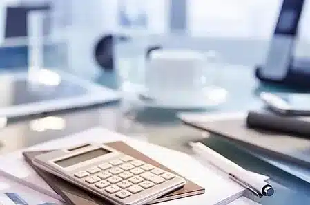 calculatrice stylo et tasse sur un bureau a la mfr rhone