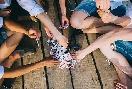 groupe de personnes jouant aux cartes sur un ponton en bois
