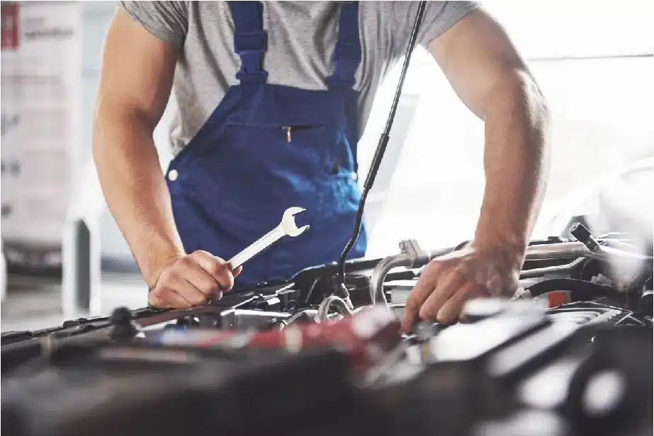 mecanicien mfr en tenue bleue travaillant sur un moteur avec