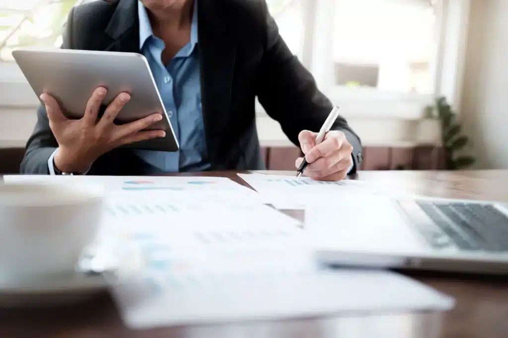 personne travaillant sur tablette et documents avec stylo mf
